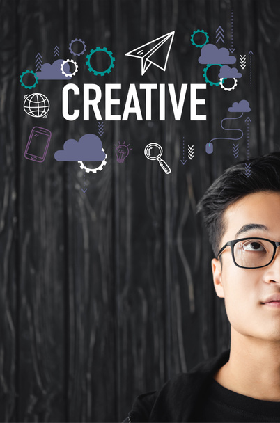 cropped view of asian man in glasses looking at illustration with creative lettering - Фото, изображение
