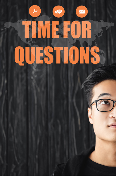 質問のレタリングのための時間とイラストを見てメガネでアジア人男性のクロップドビュー  - 写真・画像