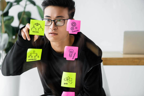 asian seo manager writing on sticky note with illustration - Foto, Imagem