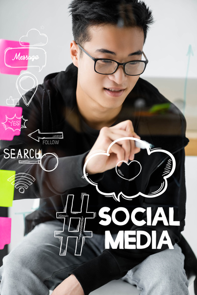 asiatique seo manager écriture sur verre avec illustration de médias sociaux lettrage
  - Photo, image