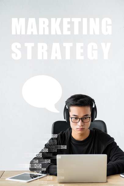 Менеджер с ноутбуком, сидящий рядом с иллюстрацией маркетинговой стратегии
 - Фото, изображение