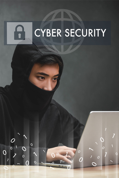 asian hacker using laptop and sitting near cyber security illustration  - Фото, изображение