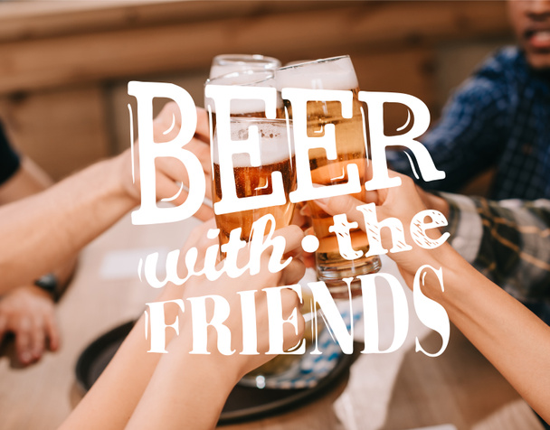 cropped view of multicultural friends clinking glasses with beer in pub with beer with the friends illustration - Fotografie, Obrázek