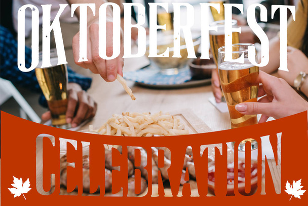 rajattu näkymä ystävien oluen juominen ja välipalojen syöminen pubissa Oktoberfest juhla kuva
 - Valokuva, kuva