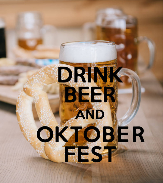 κορυφαία θέα τηγανητά λουκάνικα, δαχτυλίδια κρεμμυδιού, τηγανητές πατάτες, κουλούρια και κούπες με μπύρα σε ξύλινο τραπέζι σε παμπ με μπύρα ποτό και Oktoberfest εικονογράφηση - Φωτογραφία, εικόνα