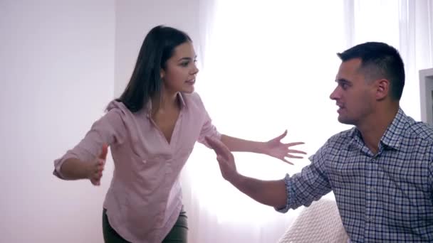 rozzlobený spor v manželském páru, Muž a žena nadávají jeden druhému během hádky kvůli zradě a agresivně mávání rukama indors - Záběry, video