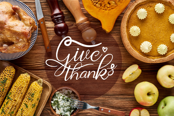 top view of roasted turkey, pumpkin pie and grilled vegetables served on wooden table with give thanks illustration - Photo, Image