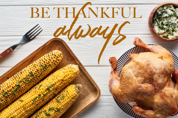 top view of roasted turkey, apples and grilled corn served on white wooden table with be thankful always illustration - Photo, Image