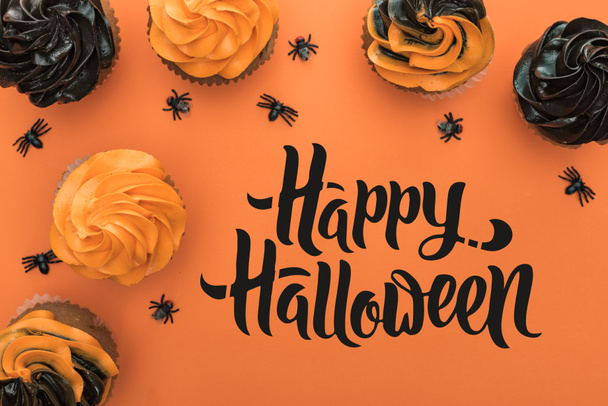 верхний вид вкусные кексы Хэллоуин с пауками на оранжевом фоне с счастливой иллюстрацией Хэллоуина
 - Фото, изображение