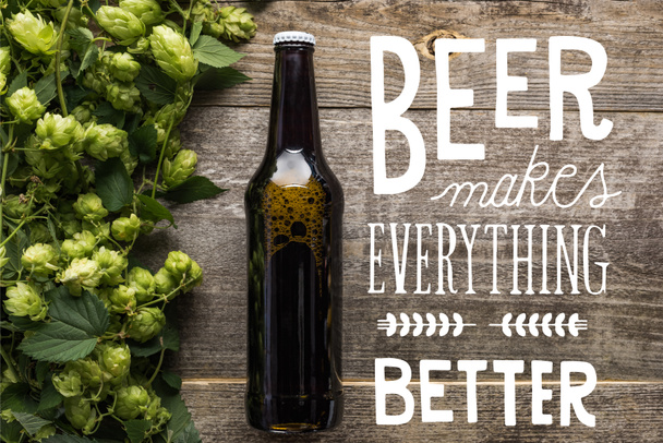 vista superior de la cerveza fresca en botella con lúpulo verde en la superficie de madera con cerveza blanca hace todo mejor ilustración
 - Foto, Imagen