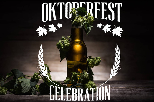 birra fresca in bottiglia con luppolo verde sulla superficie di legno al buio con illustrazione bianca Oktoberfest celebrazione
 - Foto, immagini
