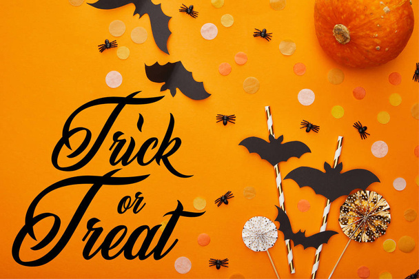 vue du dessus de citrouille, chauves-souris et araignées avec confettis sur fond orange avec astuce ou friandise illustration, décoration d'Halloween
 - Photo, image