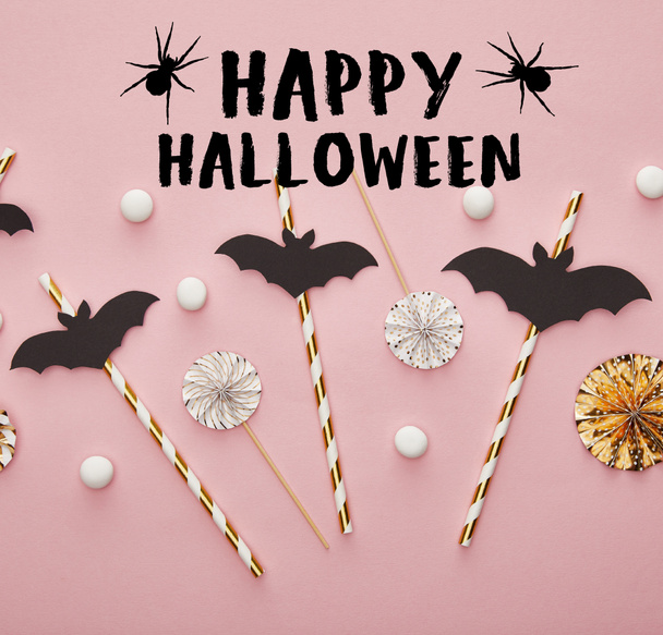 top view of bats on sticks on pink background with happy Halloween and spiders illustration, Halloween decoration - Photo, Image