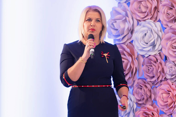 Beautiful business blonde woman with microphone in her hand spea - Fotografie, Obrázek