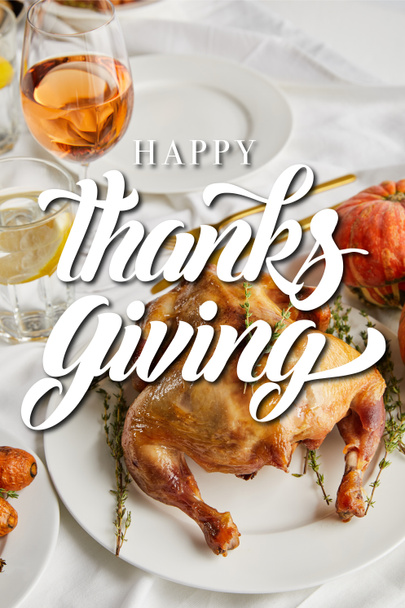 grilled turkey near glasses with white wine and lemon water on white tablecloth with happy thanksgiving illustration - Photo, image