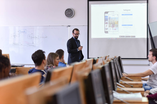 Männlicher Professor erklärt Studenten Lektion und interagiert mit ihnen - Foto, Bild