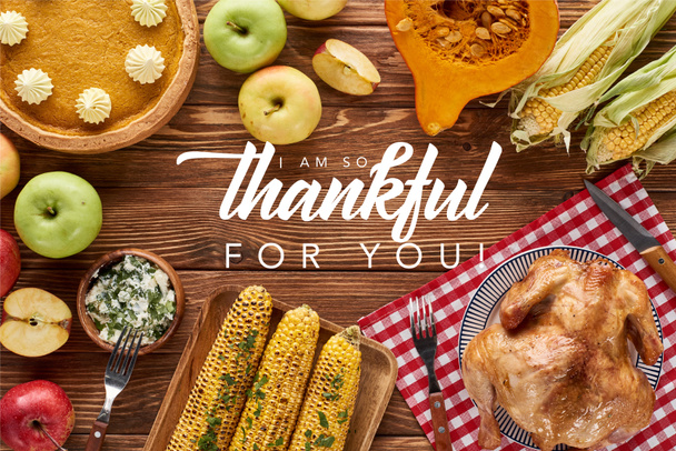 top view of pumpkin pie, turkey and vegetables served at wooden table with i am so thankful for you illustration - Photo, Image