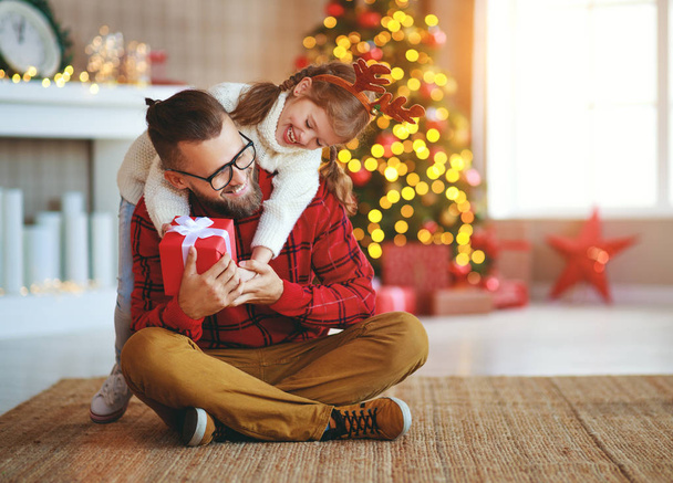 щаслива сім'я батько і дитина дочка дарують різдвяний подарунок
  - Фото, зображення