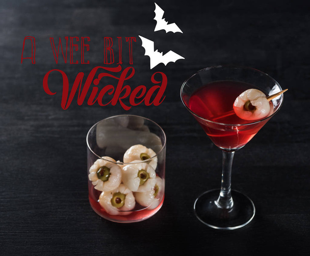 rood versierde Halloween cocktail op zwarte achtergrond met een klein beetje boze illustratie - Foto, afbeelding