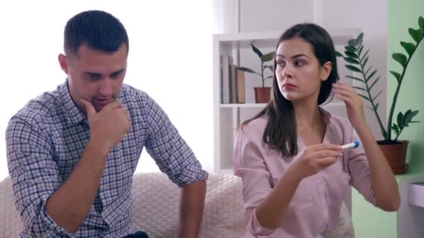 Sosiaaliset ongelmat perheessä, äitiys vaimo miehensä kanssa positiivinen raskaustesti raivoissaan tuloksista valoisassa huoneessa
 - Materiaali, video