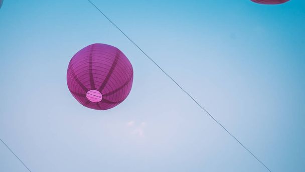 Iso violetti kiinalainen taskulamppu sinisellä taivaalla
 - Valokuva, kuva