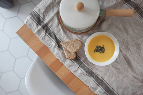 pumpkin cream soup with pumpkin seeds and crackers on a wooden table. View from above. Healthy eating concept - Φωτογραφία, εικόνα