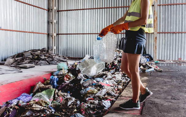 Woman-volunteer sorting trash at modern recycling plant - Фото, зображення
