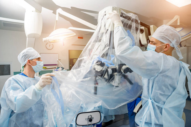 Brain surgery. Group of surgeons in operating room with surgery equipment. - Photo, Image
