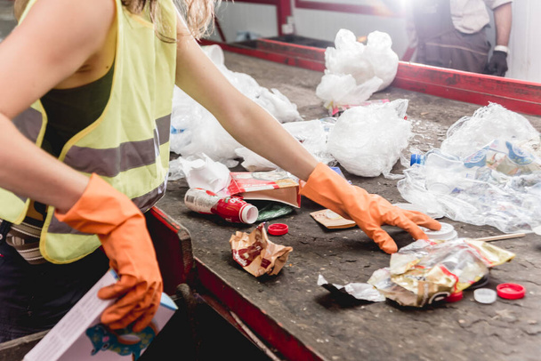 Worker separating garbage collection at modern recycling plant - Foto, afbeelding