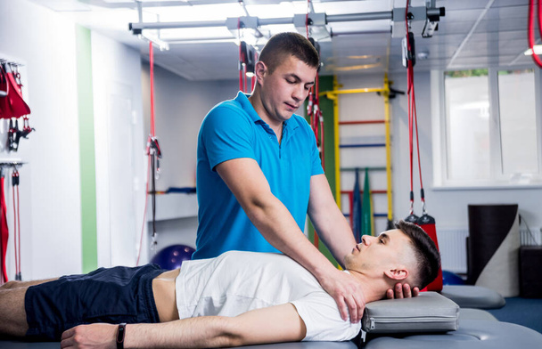 Rehabilitation therapy. Physiotherapist working with young male patient in the rehabilitation center - Valokuva, kuva
