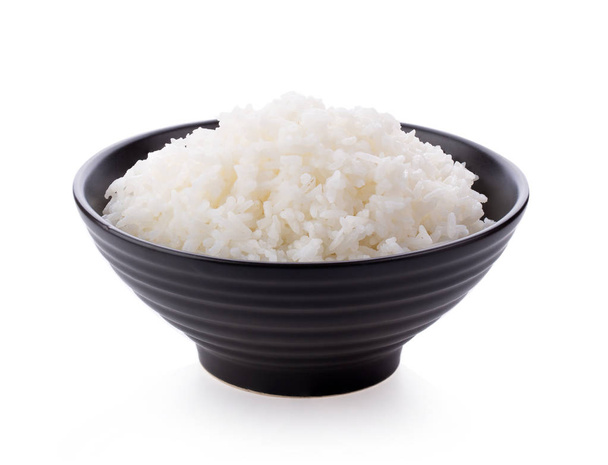 Rice in a black bowl on a white background - Foto, afbeelding