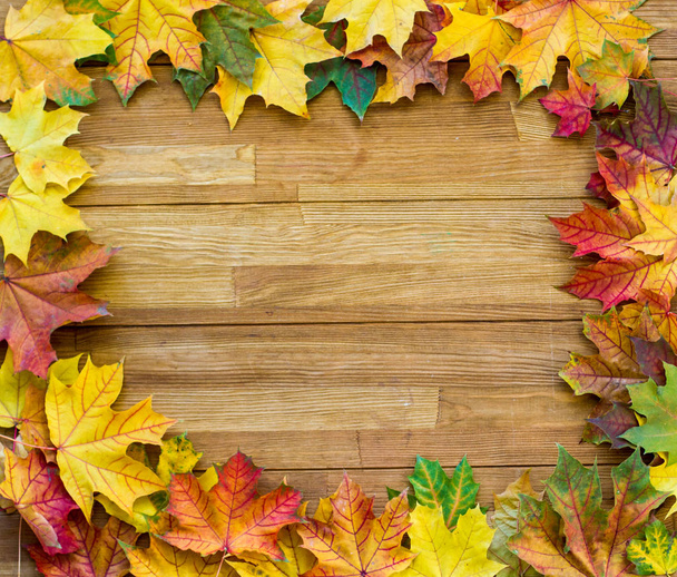 Podzimní listí na dřevěném stole. Jasné a krásné podzimní pozadí - Fotografie, Obrázek