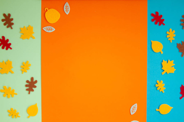 Paper leaves for Halloween party are laid out on an orange background.  - Photo, Image