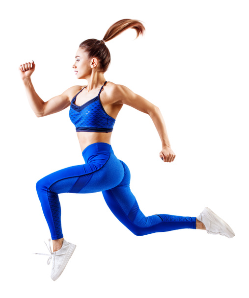 Jonge vrouw runner in blauwe sportkleding springen in de lucht. - Foto, afbeelding
