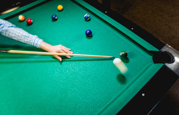 Young man trying to hit the ball in billiard. Pool background - Photo, Image