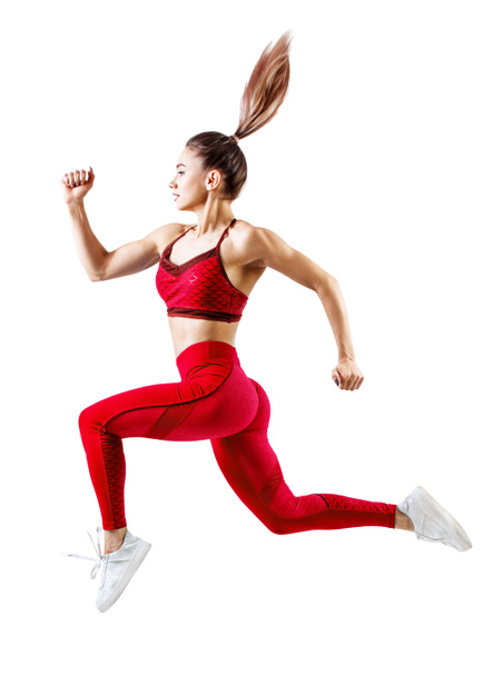 Młoda kobieta biegacz w czerwonej odzieży sportowej skakać w powietrzu. - Zdjęcie, obraz