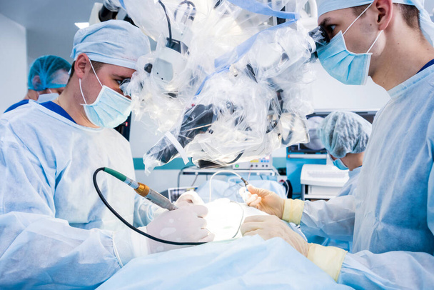 Spinal surgery. Group of surgeons in operating room with surgery equipment. Laminectomy. Modern medical background - Foto, Bild