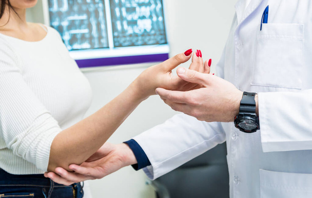 close up of traumatologist examining patient hands in modern hospital - Foto, Imagem