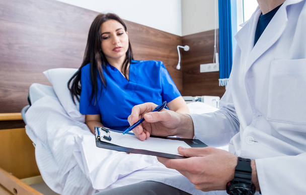 Traumatologist talking with young female patient in modern hospital. Medical concept - Photo, image