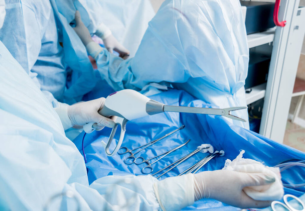 Process of surgery operation using laparoscopic equipment. Group of surgeons in operating room with surgery equipment. Medical background - Valokuva, kuva