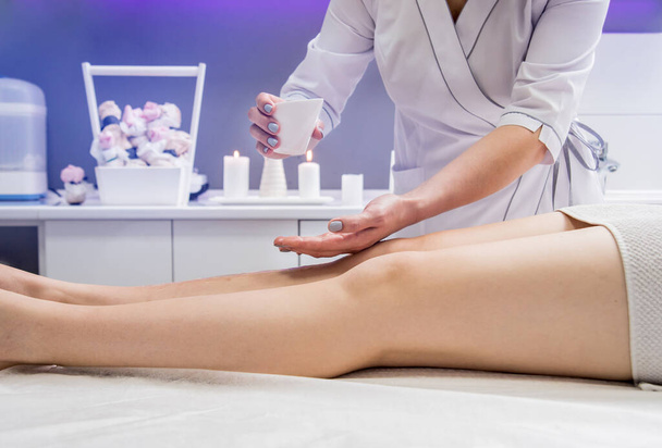 Hermosa mujer joven disfrutando de masajes en las piernas en el salón de spa. Concepto de cosmetología
 - Foto, imagen