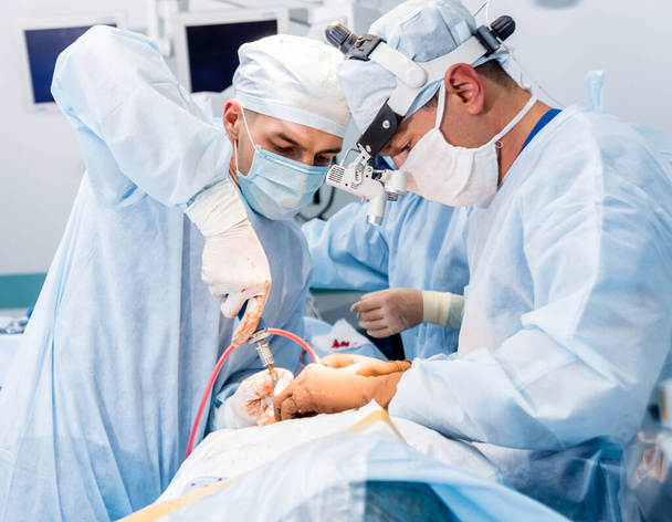 Spinal surgery. Group of surgeons in operating room with surgery equipment. Laminectomy. Modern medical background - Foto, imagen