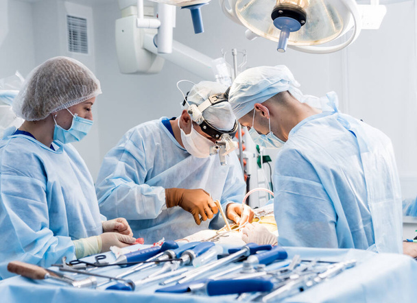 Spinal surgery. Group of surgeons in operating room with surgery equipment. Laminectomy. Modern medical background - Фото, зображення