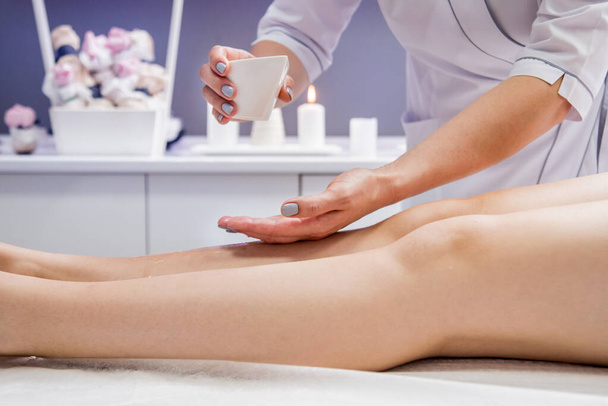 Beautiful young woman enjoying legs massage in spa salon. Cosmetology concept - Valokuva, kuva