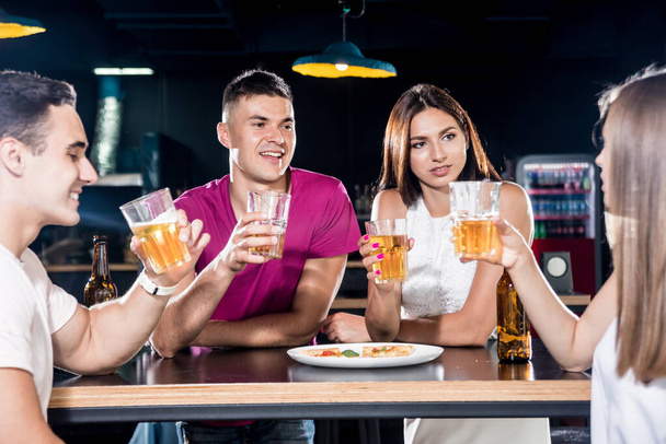Cheerful friends in the pub. Drinking beer, talking, having fun. Meeting friends after work - Foto, Imagen