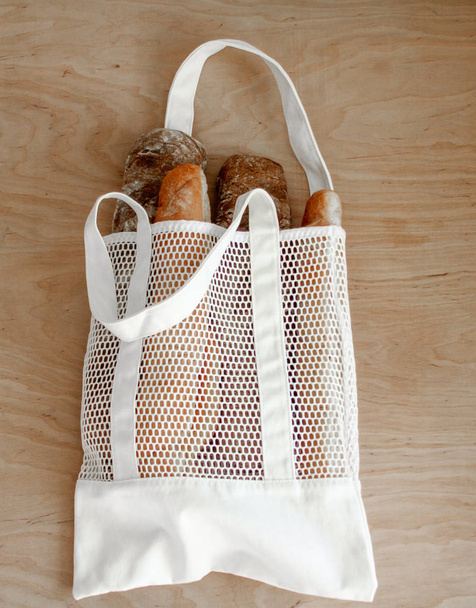 Tasche mit selbstgebackenem Brot auf Holzoberfläche - Foto, Bild