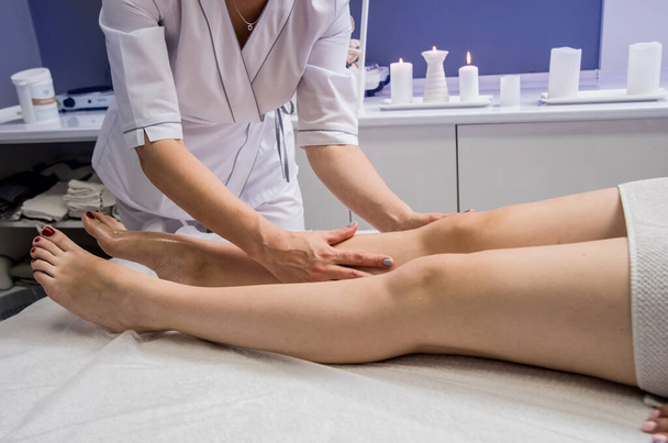 Beautiful young woman enjoying legs massage in spa salon. Cosmetology concept - Φωτογραφία, εικόνα
