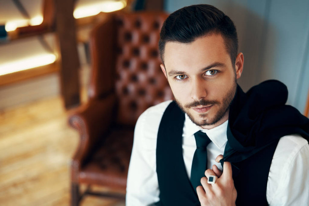 Handsome young man in elegant suit in modern luxury interior. Fashion portrait              - Фото, изображение