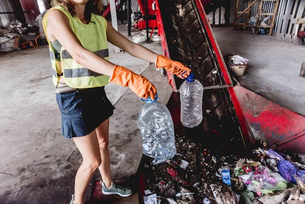 Woman-volunteer sorting trash at modern recycling plant - Zdjęcie, obraz
