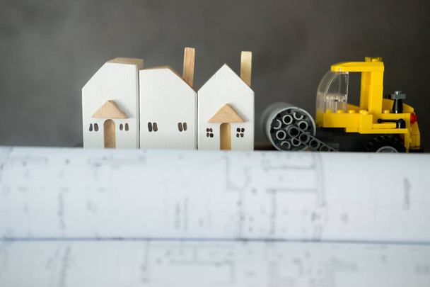 Brinquedo carro de construção amarelo no plano de desenho arquitetônico
  - Foto, Imagem